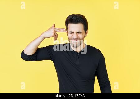 Giovane uomo che fa il gesto di sparare voi stessi Foto Stock