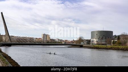 Pontevedra, Galizia / Spagna - 2 dicembre 2020: Kayak sul fiume Pontevedra con il ponte Dos Tirantes e Pazo da Cultura alle spalle Foto Stock