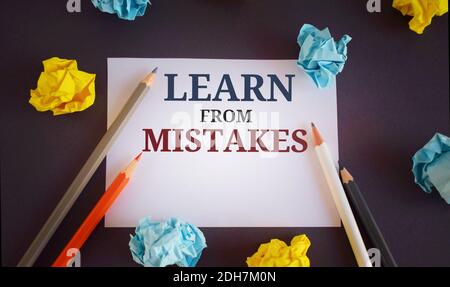 Scrittura del testo Impara dagli errori. Concetto che significa tenere traccia delle vostre decisioni più importanti.matite e lobi di carta su sfondo scuro Foto Stock