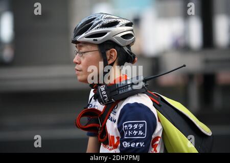 Uomo asiatico che lavora come una moto courie a Tokyo, Giappone Foto Stock