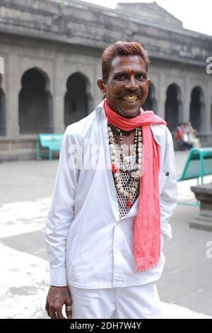 Uomo indiano con denti dorati metallici nell'antico tempio indù di Kalaram nel quartiere Nashik di Nashik nel Maharashtra. Foto Stock