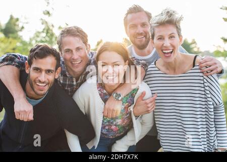 Ritratto di gruppo di amici felici che si divertano al pic-nic sul lungolago Foto Stock