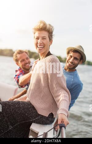 Ritratto di felice donna godendo con gli amici su yacht Foto Stock