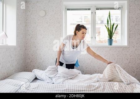 Donna rendendo letto Foto Stock