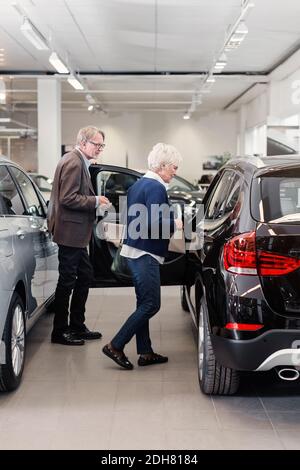 Coppia senior che esamina l'auto in negozio Foto Stock