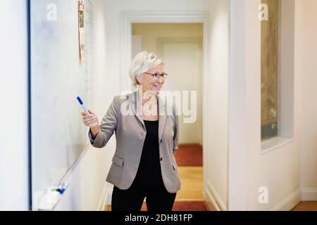 Donna d'affari anziana che dà la presentazione in ufficio Foto Stock