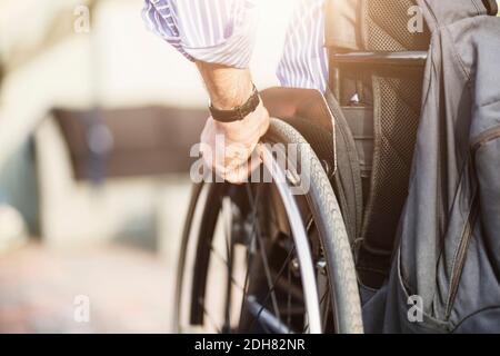 Immagine ritagliata dell'uomo in sedia a rotelle all'aperto Foto Stock