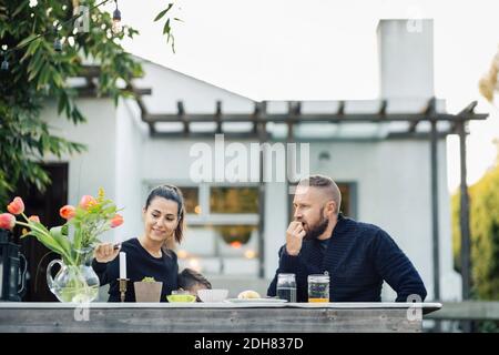 Uomo che guarda la candela di illuminazione donna al cortile Foto Stock