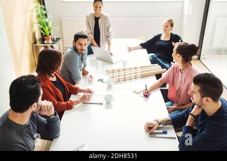 Vista ad alto angolo delle persone che discutano al tavolo in sala riunioni Foto Stock