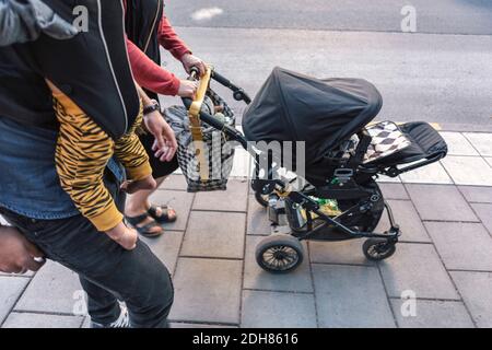 I genitori con il bambino e passeggino che camminano sul marciapiede Foto Stock