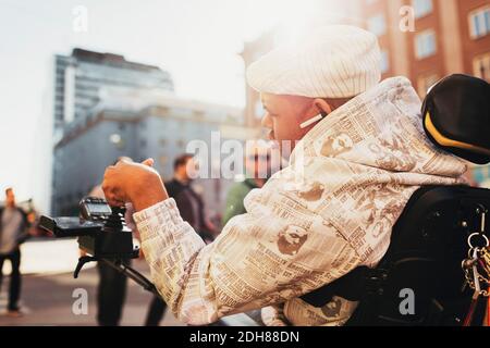 Persona disabile che usa il joystick della sedia a rotelle in città Foto Stock