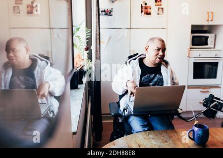 Uomo disabile con computer portatile in studio di registrazione Foto Stock