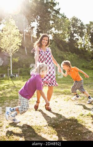 Ritratto di una madre felice che gioca con i bambini nel parco Foto Stock