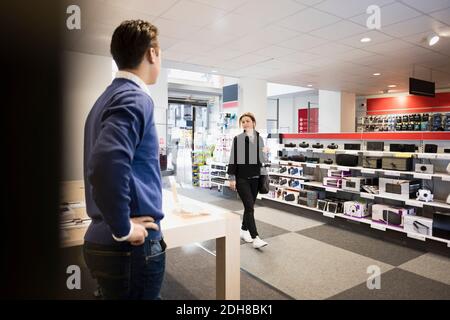 Cliente femminile che entra nel negozio di elettronica Foto Stock