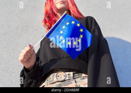 Studentessa adolescente con bandiera UE in mano, sfondo grigio parete esterna Foto Stock