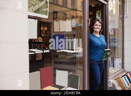 Ritratto di un libro librario sorridente mentre si trova alla porta Foto Stock