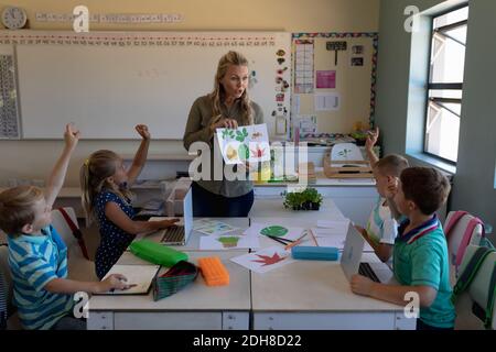 Insegnante femminile con capelli biondi lunghi in piedi in classe Foto Stock