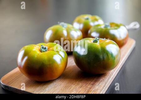 Pomodori biologici Black Krim su un tagliere Foto Stock