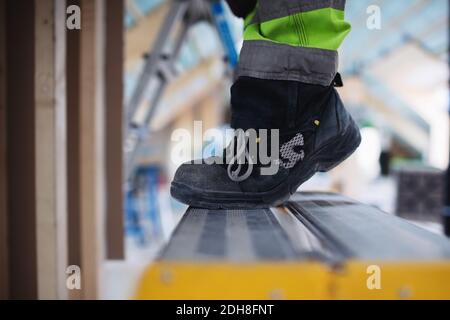 Sezione bassa di scarpe da uomo in piedi sulla scala Foto Stock