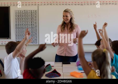 Insegnante femminile con capelli biondi lunghi in piedi su una tavola bianca Foto Stock