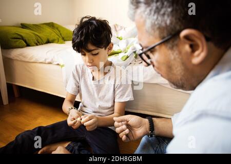 Padre e figlio suonano a casa con band di gomma Foto Stock