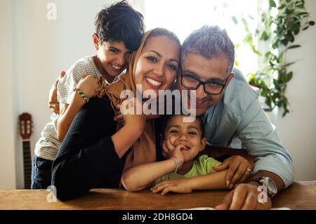 Ritratto di felice famiglia seduto al tavolo Foto Stock
