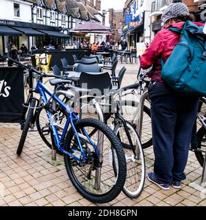 Kingston London, dicembre 09 2020, Donna pronta a partire sulla sua bicicletta in un Grey Winters Day con tavolo vuoto e sedie in background Foto Stock