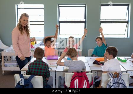 Insegnante femminile con capelli biondi lunghi in piedi in classe Foto Stock
