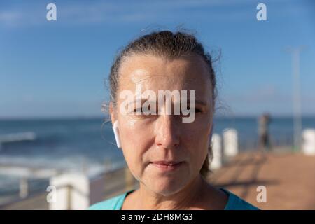 Pareggiatore femminile che guarda la macchina fotografica sul mare Foto Stock