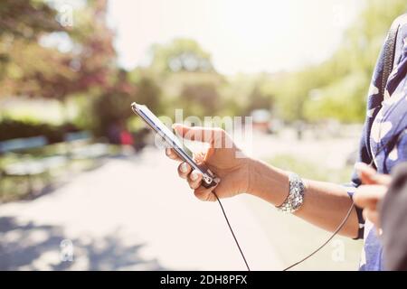 Immagine ritagliata di donna d'affari che tiene lo smartphone sul sentiero a piedi parcheggio Foto Stock