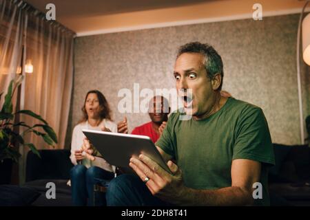 Uomo deluso e sconvolto che utilizza il tablet digitale durante gli eventi sportivi Foto Stock