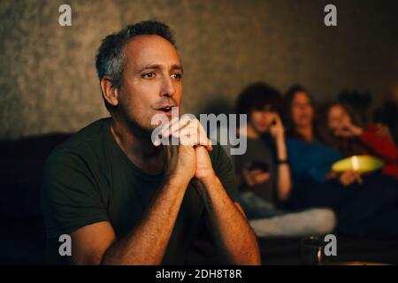 L'uomo speranzoso prega mentre guarda gli sport di notte Foto Stock