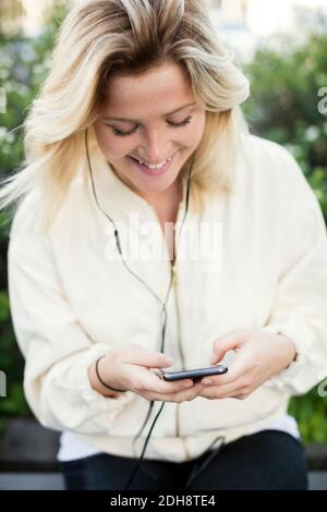 Felice giovane donna utilizzando smart phone Foto Stock
