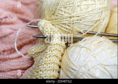 Aghi per maglieria, matasse di filato e tessuto a maglia, tessuti per la casa. Primo piano, messa a fuoco selettiva Foto Stock