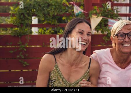 Allegre donne mature che godono di festa in giardino nel cortile posteriore Foto Stock