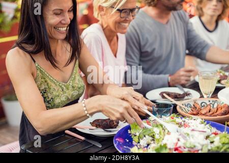 Persone felici seduti al tavolo da pranzo durante la festa in giardino cortile posteriore Foto Stock