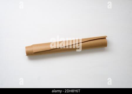 un rotolo di carta artigianale su uno sfondo chiaro al centro, spazio di copia. Foto Stock