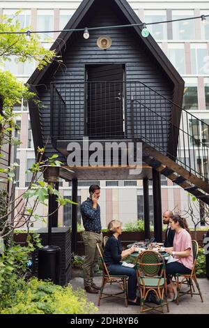 Uomini d'affari che pranzano nel cortile d'ufficio Foto Stock