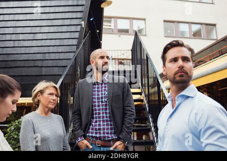 Uomini d'affari che si guardano fuori dalla cabina di legno Foto Stock