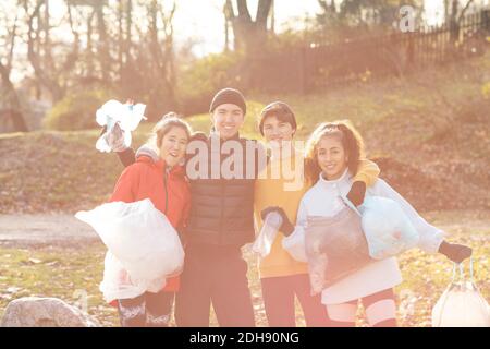 Sorridente ambientalisti maschili e femminili con rifiuti in microplastica in piedi parcheggio Foto Stock