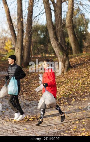 Ambientalisti maschili e femminili che parano nel parco Foto Stock