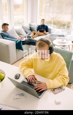 Vista ad alto angolo della ragazza utilizzando il computer portatile da tavolo a. casa Foto Stock