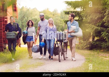 Felici gli amici con biciclette e bagagli a piedi lungo il percorso cottage Foto Stock