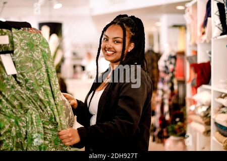 Ritratto di una cliente sorridente che si trova in un negozio di moda Foto Stock