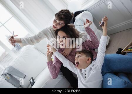 Madre allegra e figli che prendono selfie in soggiorno a. casa Foto Stock