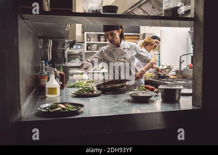 Lo chef femmina nella preparazione degli alimenti in cucina commerciale Foto Stock