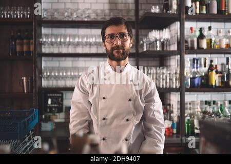 Ritratto di fiducioso maschio chef nella cucina commerciale Foto Stock