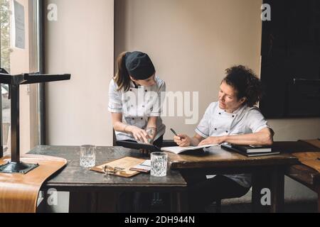 Le cuoco femminili discutono al tavolo nel ristorante Foto Stock