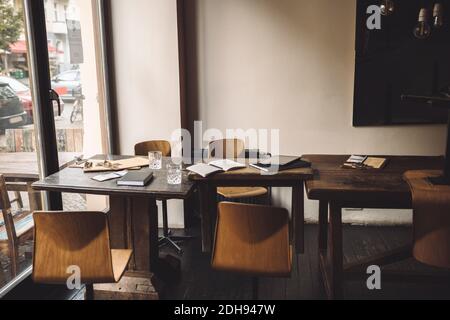 Sedie vuote con diario sul tavolo nel ristorante Foto Stock