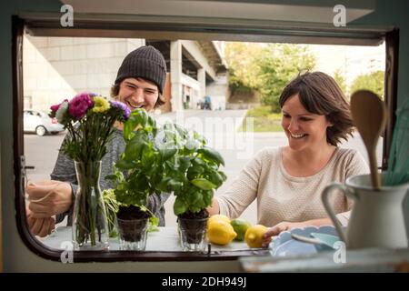 Felici proprietari di uomini e donne che lavorano al di fuori del camion alimentare Foto Stock